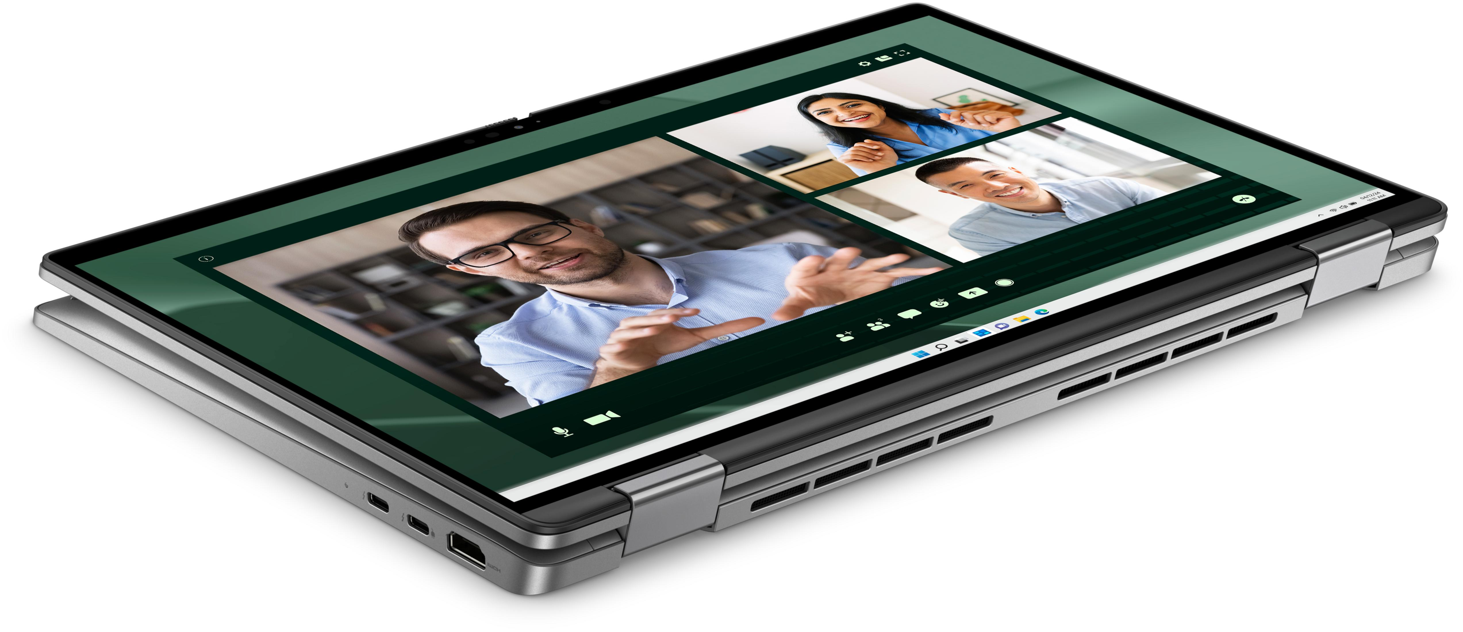Laptop zeigt Videokonferenz mit drei Personen. Mann im Vordergrund gestikuliert.