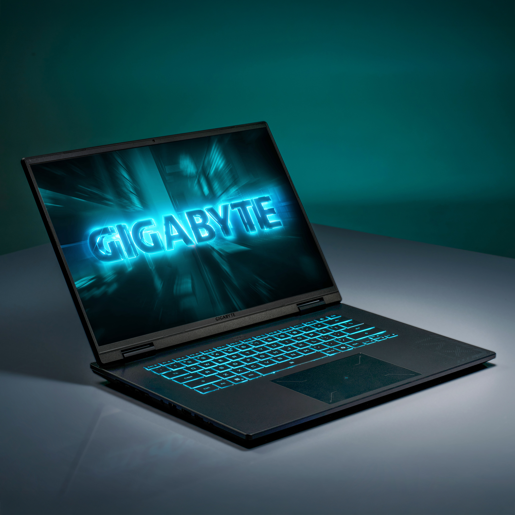 Ein geöffneter Laptop mit beleuchteter Tastatur und dem GIGABYTE-Logo auf dem Bildschirm.