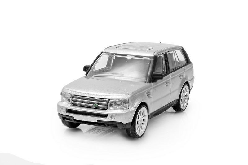 Srebrny samochodzik w stylu Range Rover na białym tle.