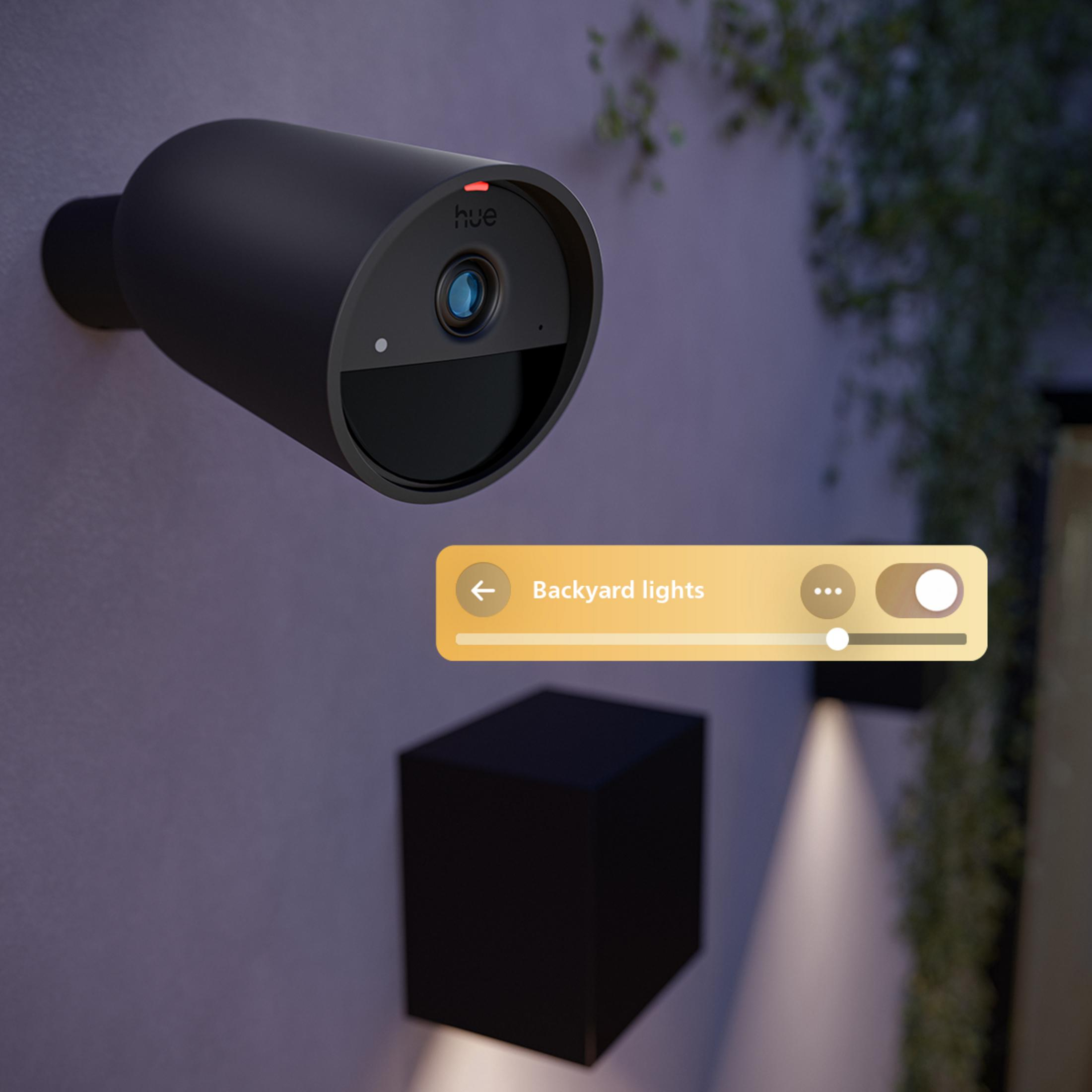 Una telecamera di sicurezza nera su un muro con una sovrapposizione UI gialla.