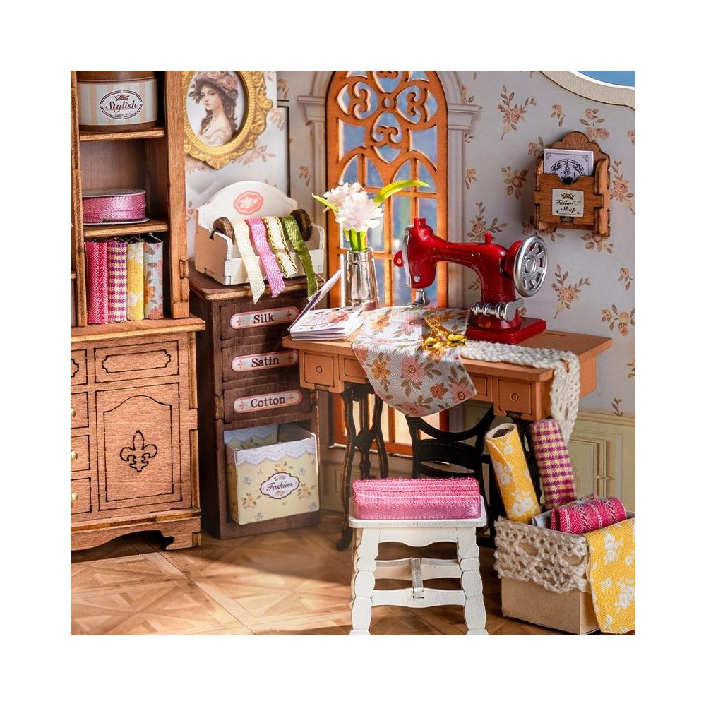 Ein Miniatur-Nähzimmer mit einer roten Nähmaschine, Stoffrollen und Bändern.