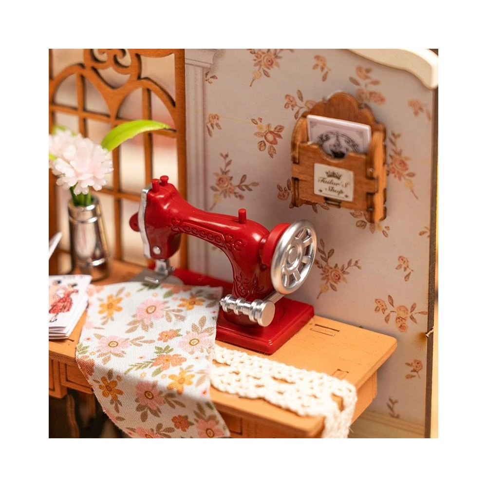 Eine rote Nähmaschine steht auf einem Holztisch mit geblümtem Stoff und einer Vase mit Blumen.