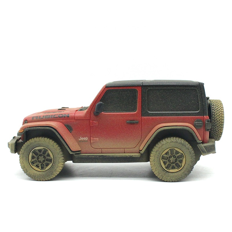 Zakurzony czerwony Jeep Wrangler Rubicon z czarnym twardym dachem na białym tle.