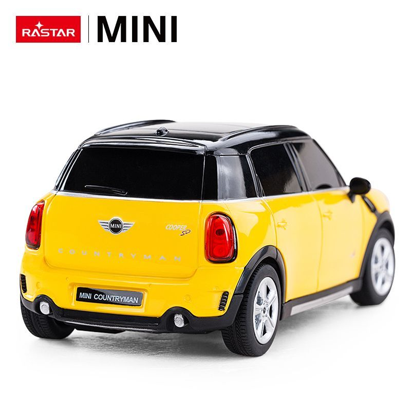 Żółty samochodzik Mini Cooper Countryman z czarnym dachem i detalami, widok z tyłu.