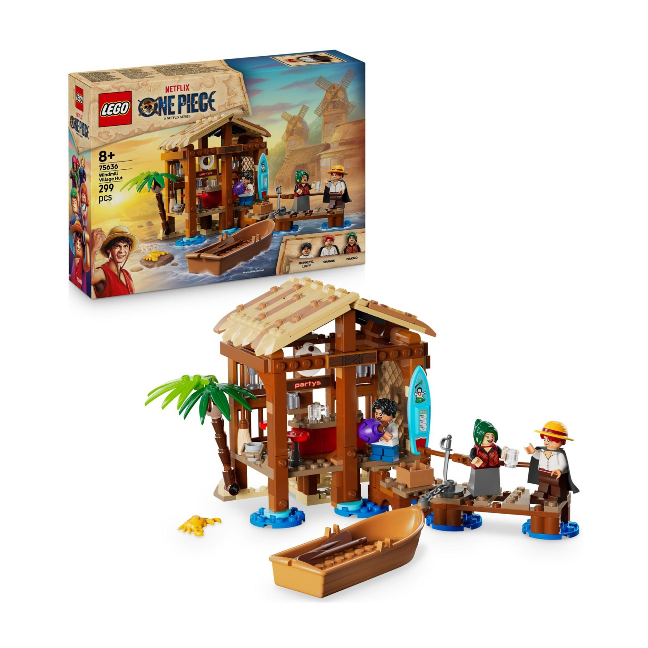 Ricostruzione Lego di una capanna con figure, barca e palme. Sullo sfondo una scatola.
