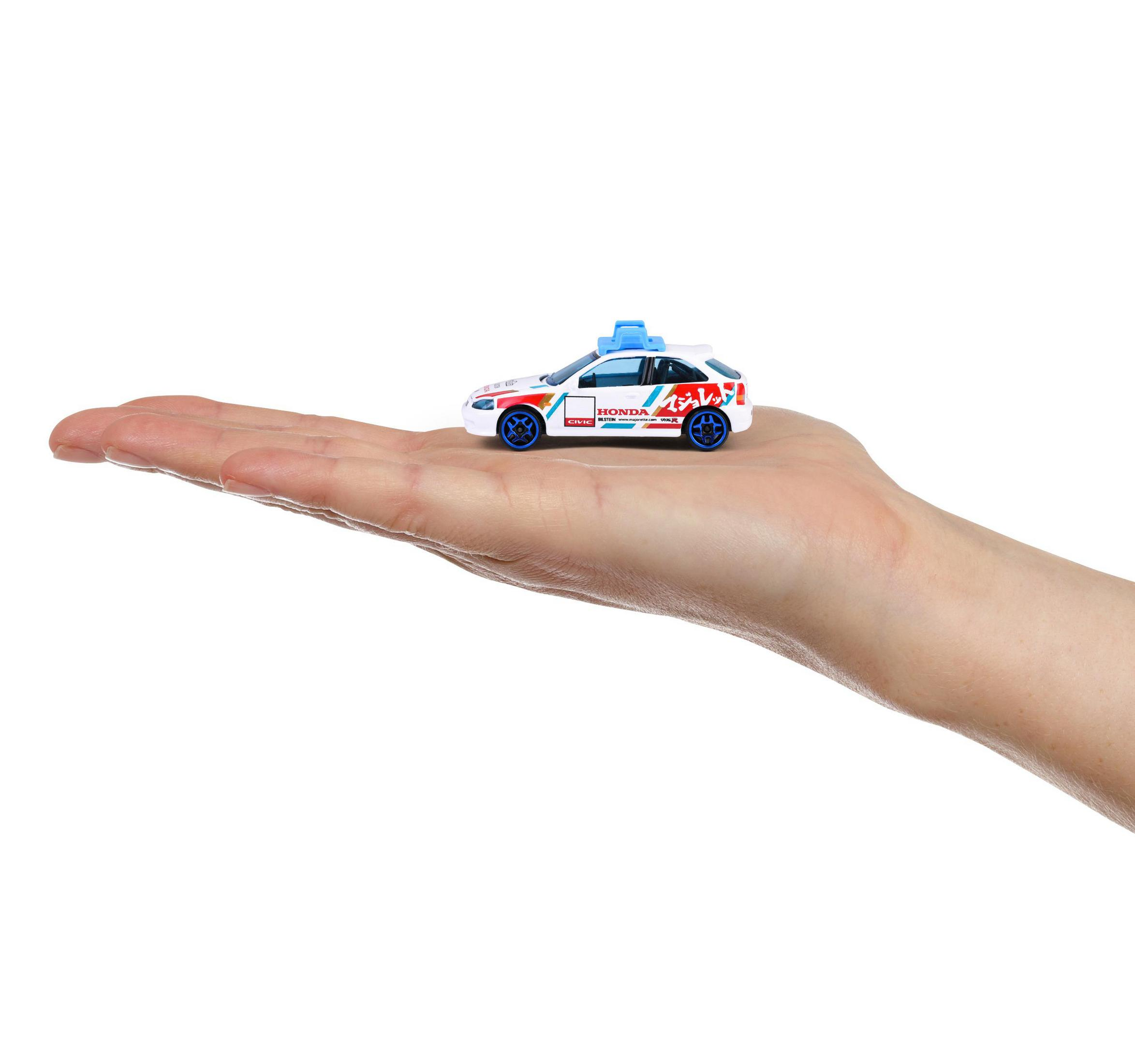 Ein kleines weißes Spielzeugauto mit blauen Felgen und japanischen Schriftzeichen auf einer Hand.