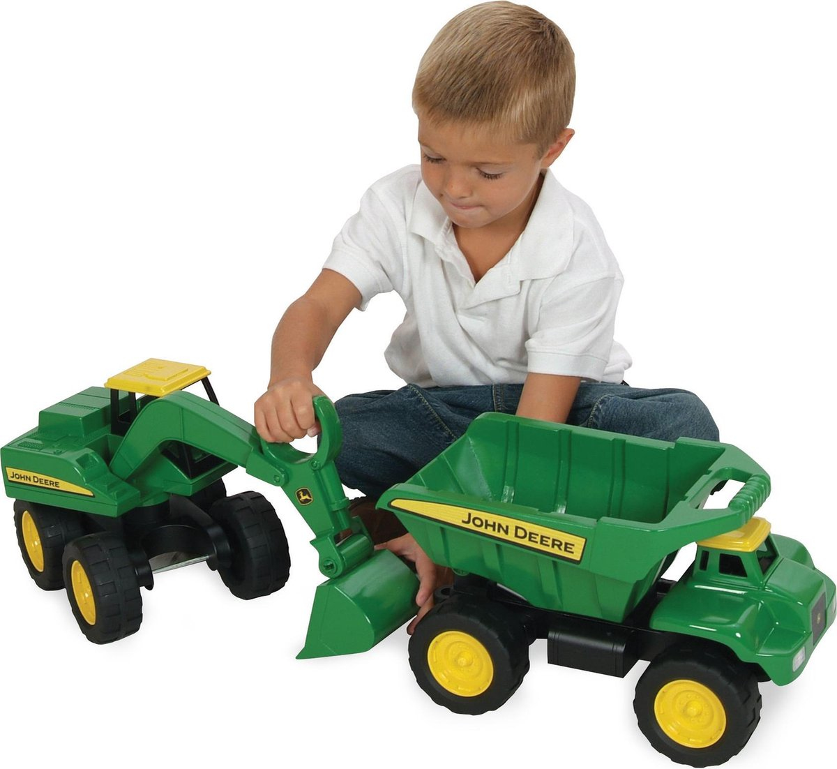 Ein Junge spielt mit grünen John Deere Spielzeugbagger und Kipper.