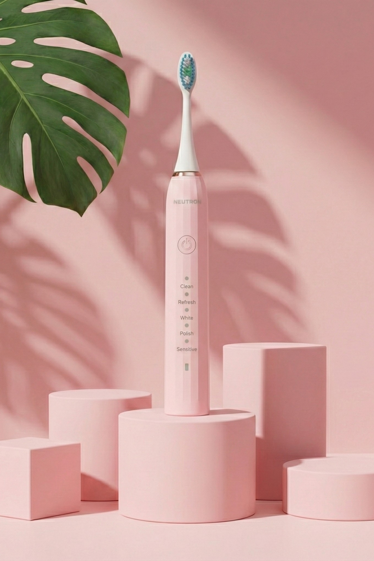 Büyük yeşil yaprak ve pembe bloklarla, pembe bir kaide üzerinde duran pembe elektrikli diş fırçası.