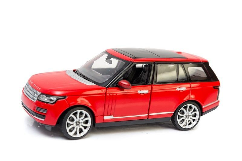 Czerwony samochódzik Range Rover z czarnym dachem na białym tle.