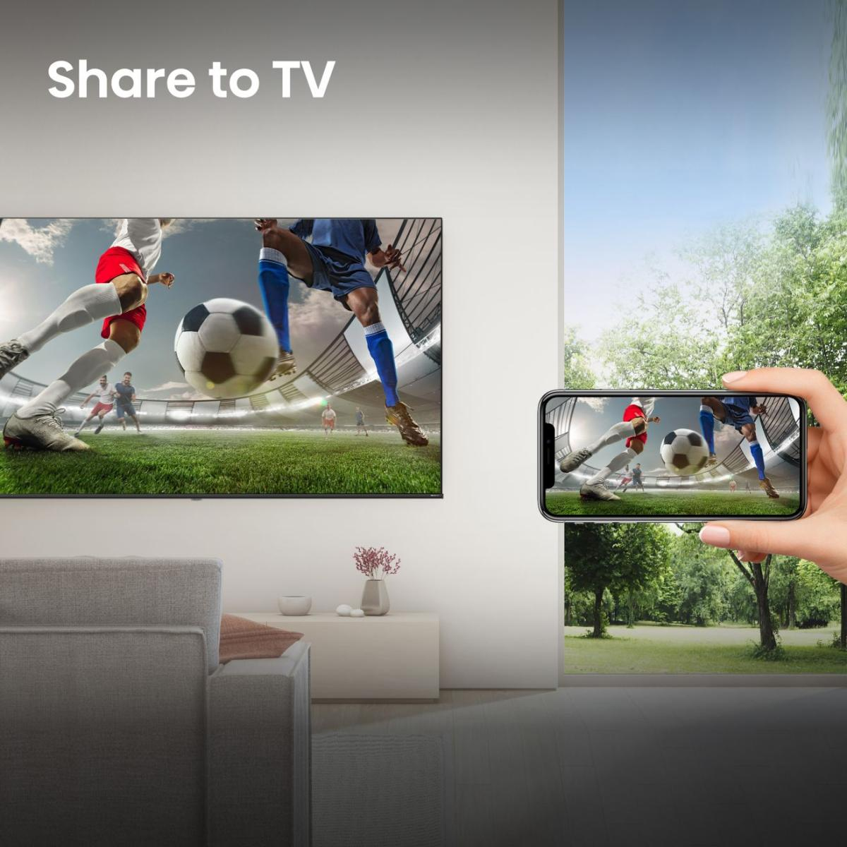 Fußballspiel auf einem großen Fernseher und Smartphone in einem Wohnzimmer.