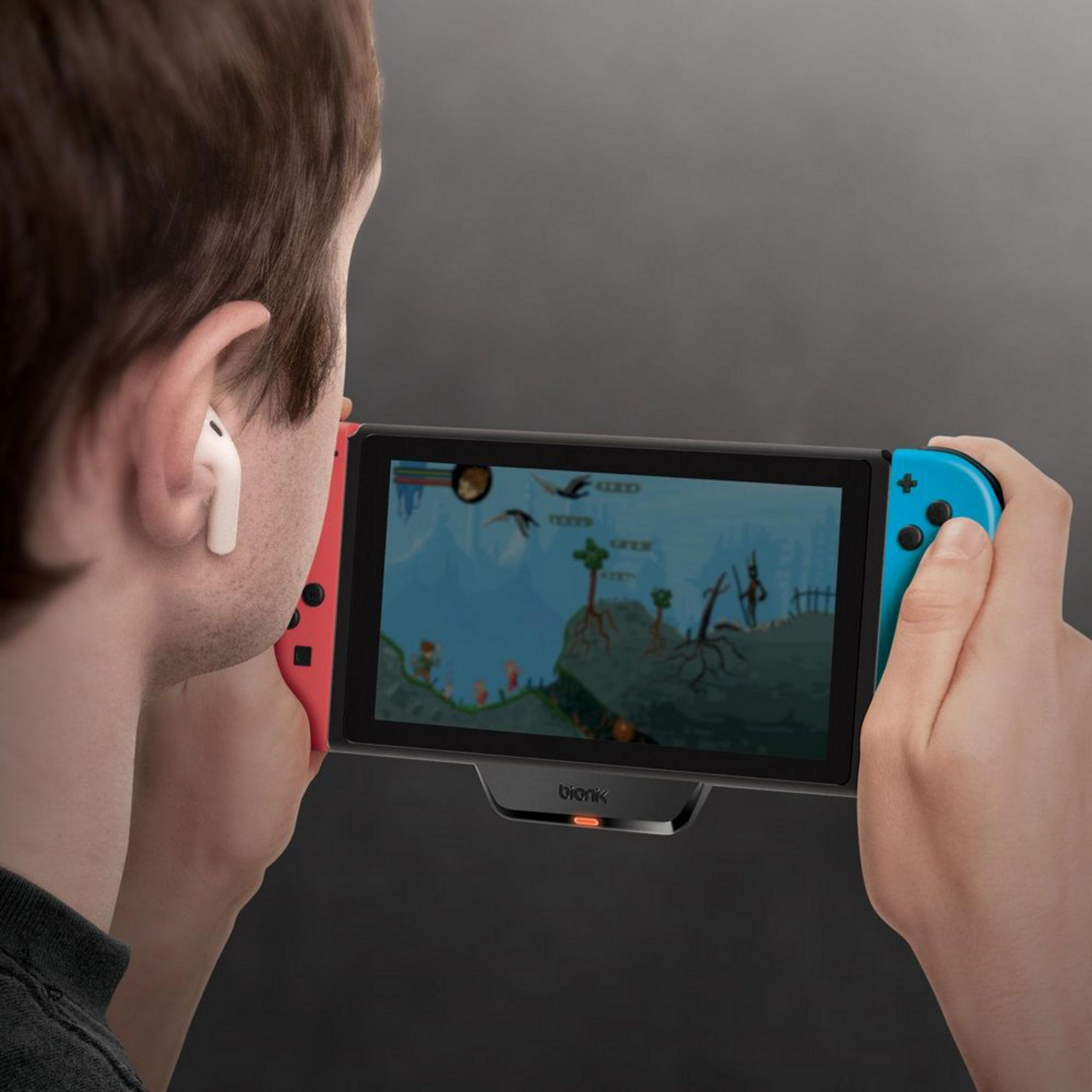 Mężczyzna gra w grę wideo na konsoli Nintendo Switch ze słuchawkami.