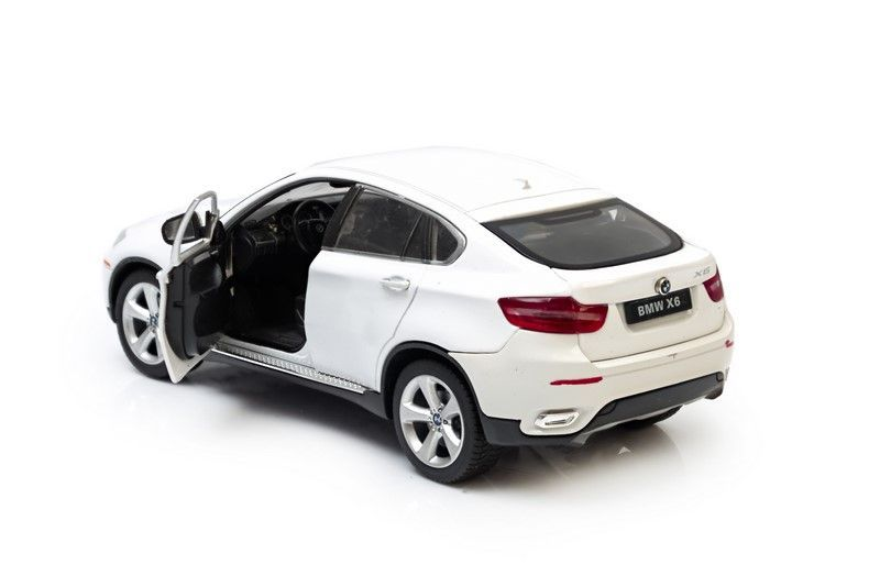 Biały model samochodu BMW X6 z otwartymi drzwiami kierowcy, na białym tle.