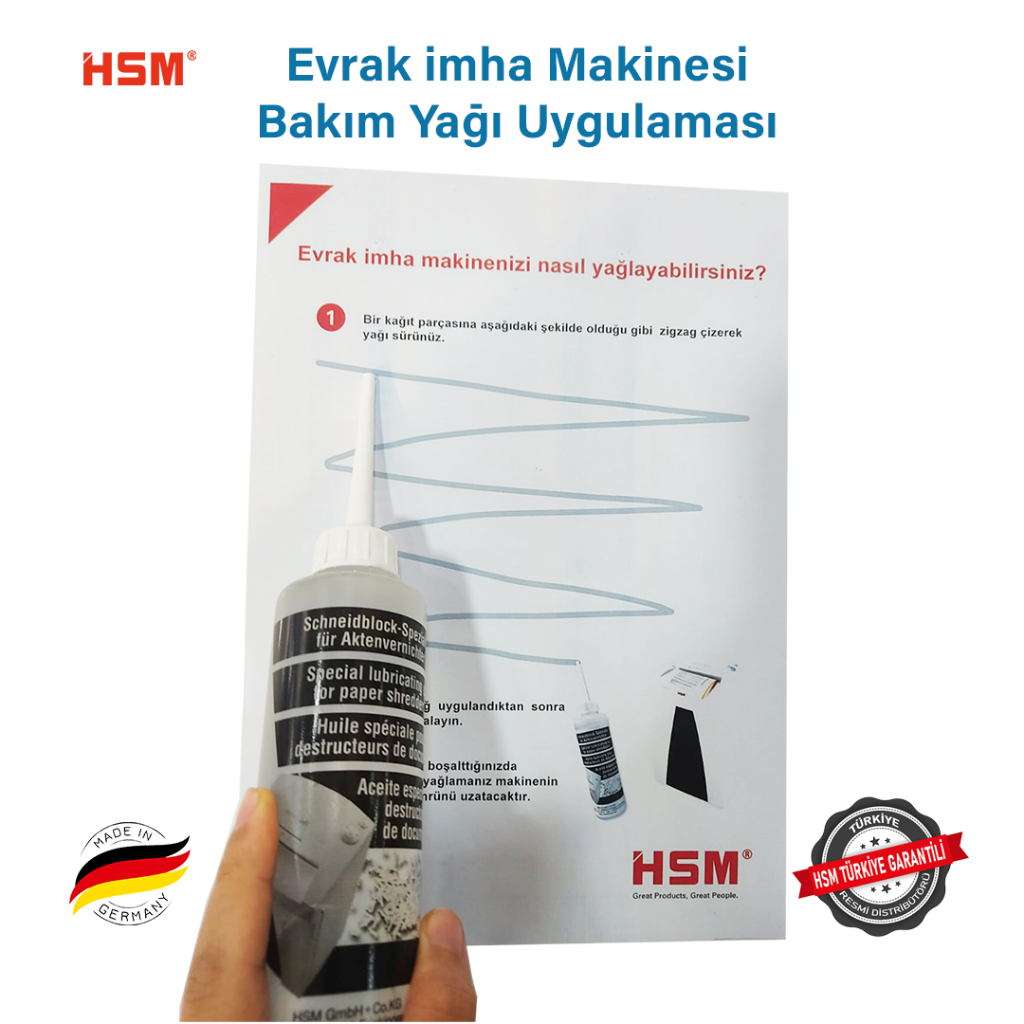 Bir adam, talimatların önünde kağıt imha makinesi yağı şişesi tutuyor.