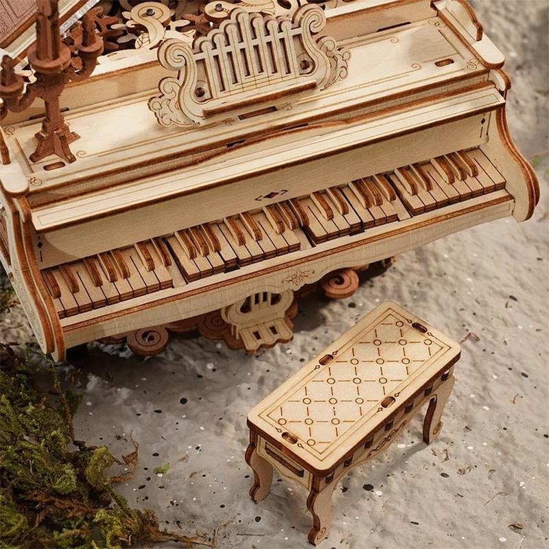 Un modèle de piano en bois avec un petit banc et de la mousse.