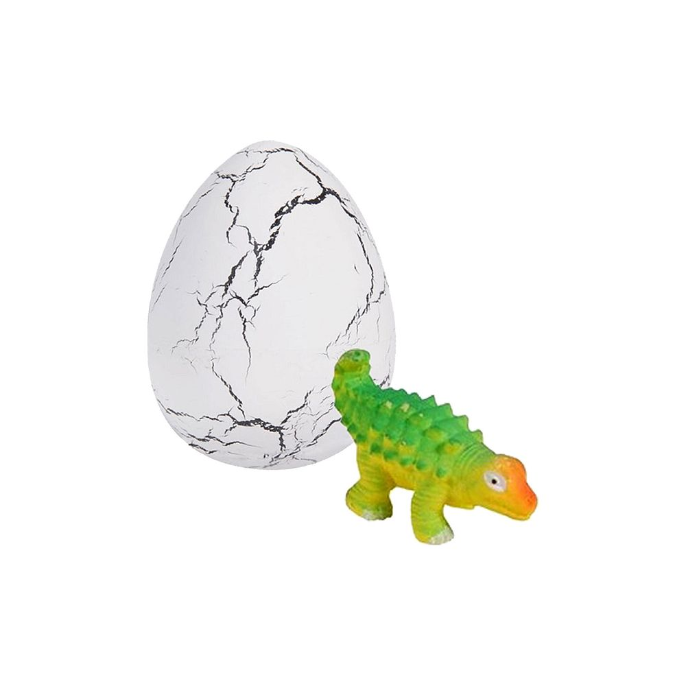 Zielony i żółty dinozaur z zabawki stoi obok pękniętego białego jajka.