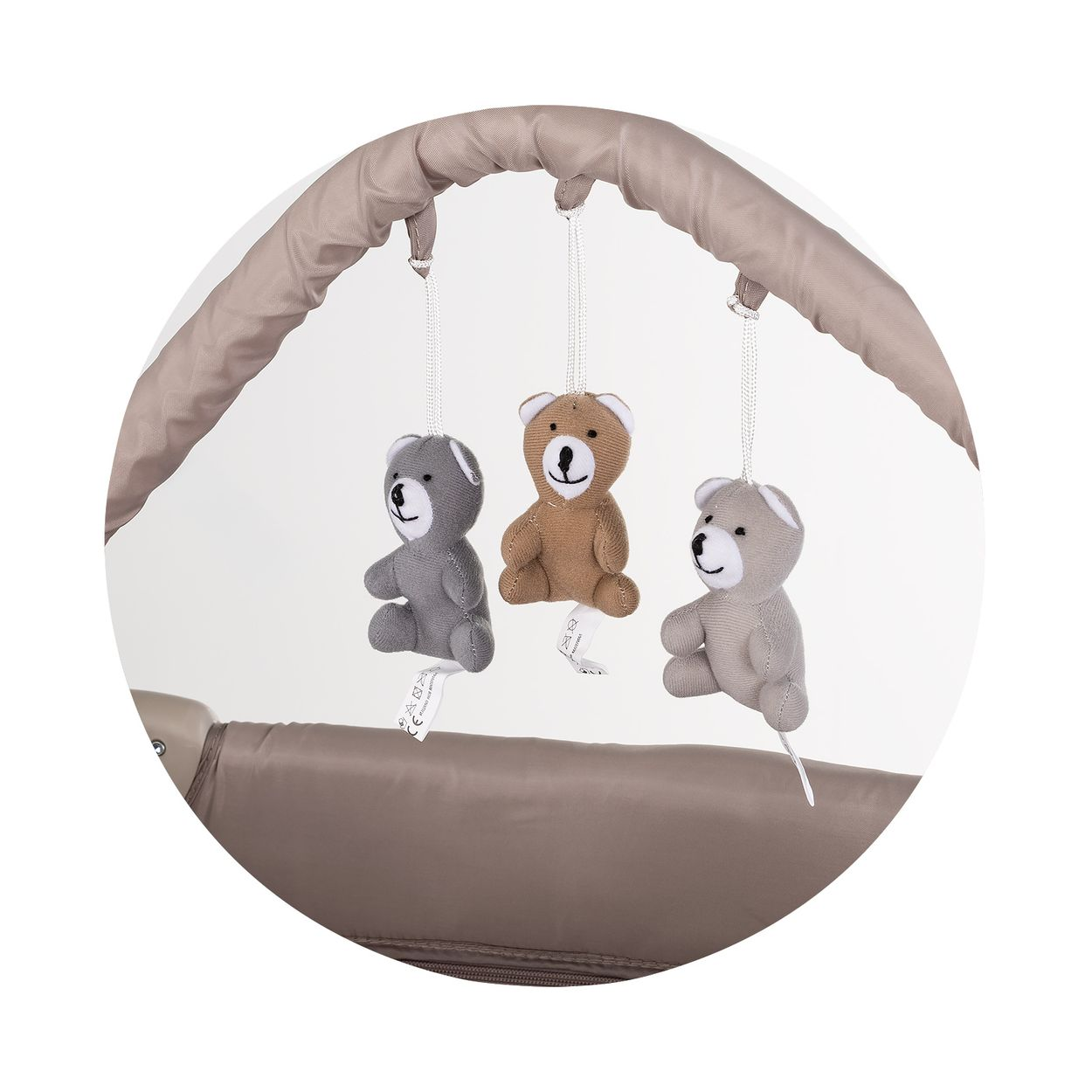 Drei Plüschbären hängen an einer Spieluhr über einem Babybett.
