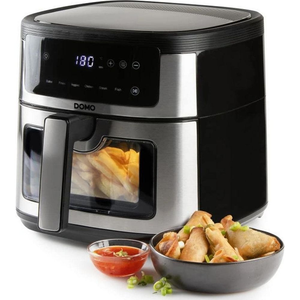 Une friteuse à air Domo avec des frites à l'intérieur et un bol de nems et de sauce.