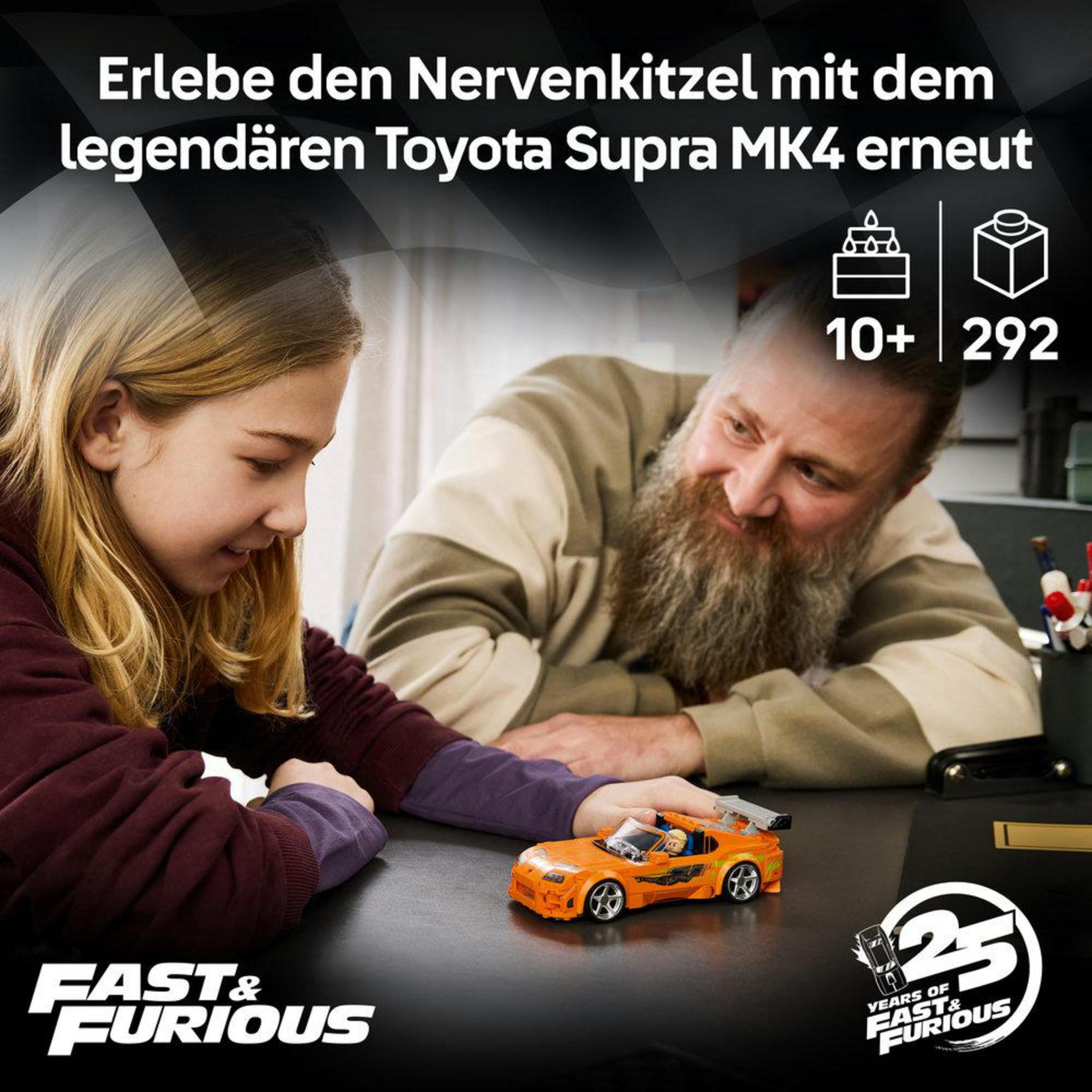Bir adam ve bir kız, "Fast & Furious" logolu turuncu oyuncak Supra'ya bakıyor.