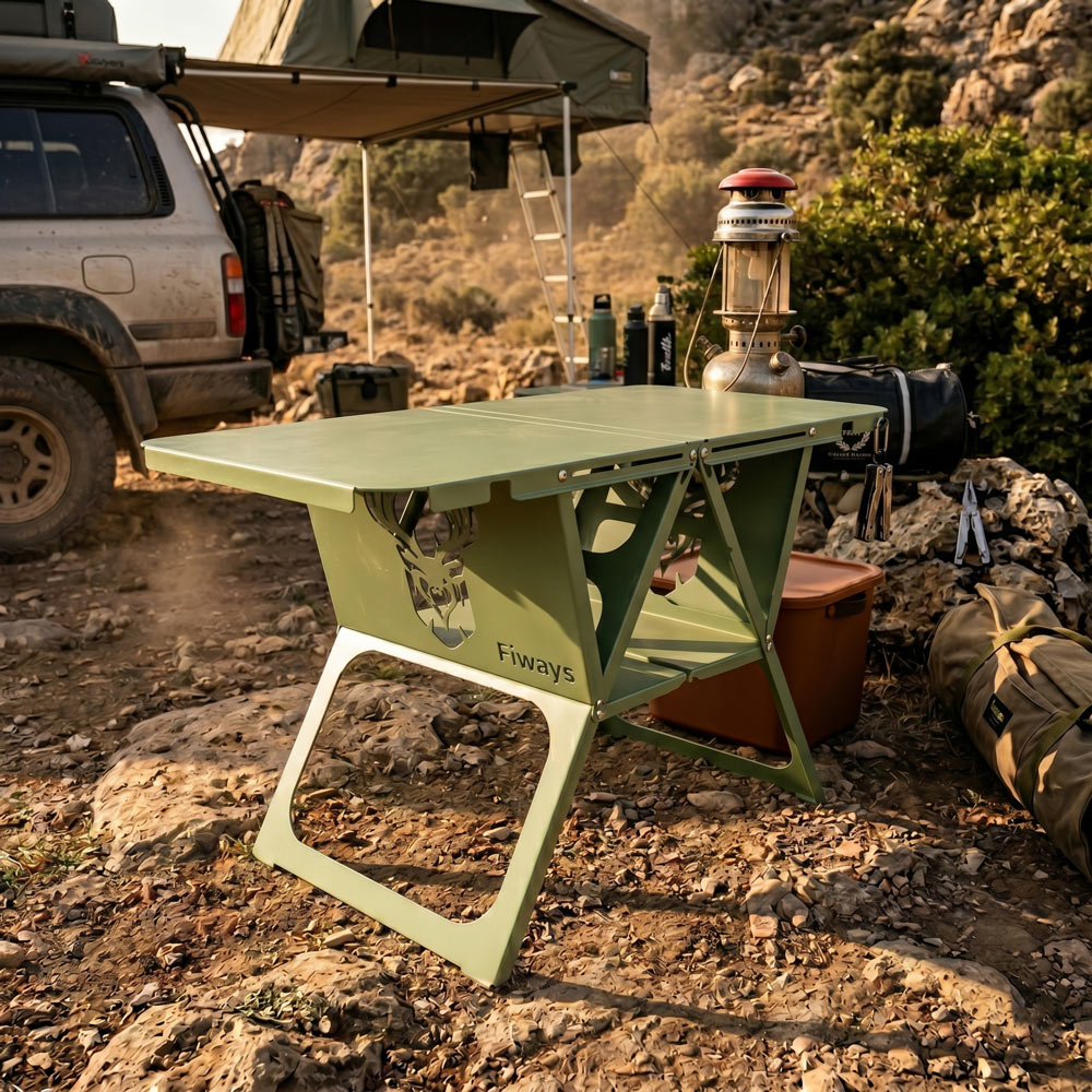SUV ve tavan çadırının önünde geyik motifli yeşil kamp masası.