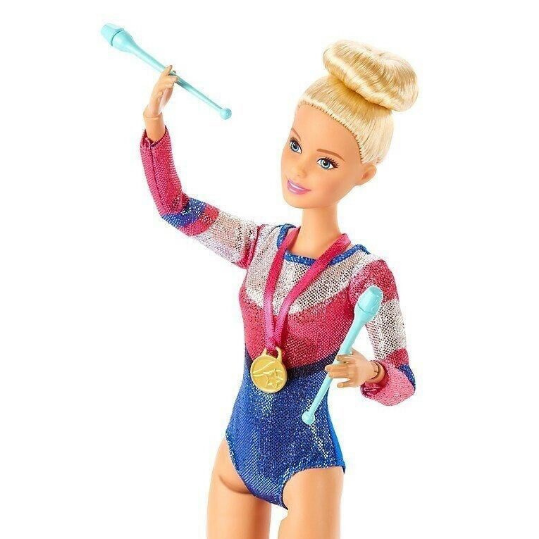 Eine Barbie-Puppe in einem glitzernden Turnanzug mit Medaille hält zwei Keulen.