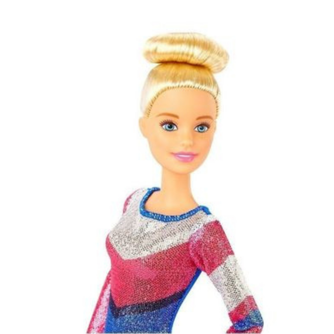 Eine Barbie-Puppe mit blondem Haar in einem Dutt, blauen Augen und einem glitzernden Anzug.