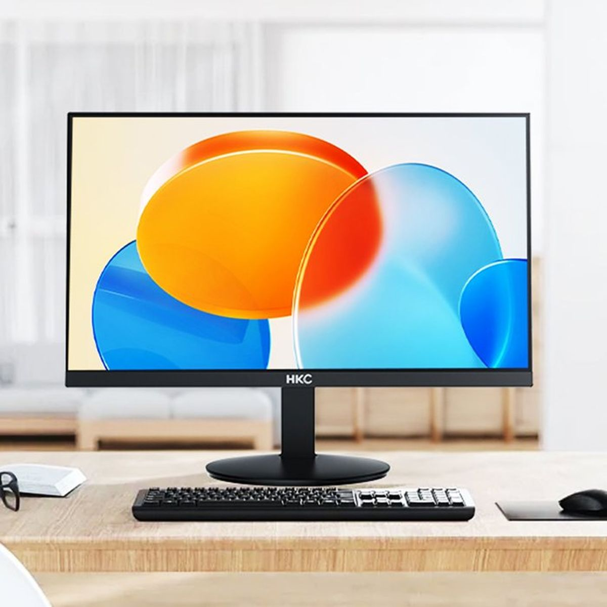 Un moderno monitor HKC su una scrivania con tastiera e mouse. Arte astratta sullo schermo.