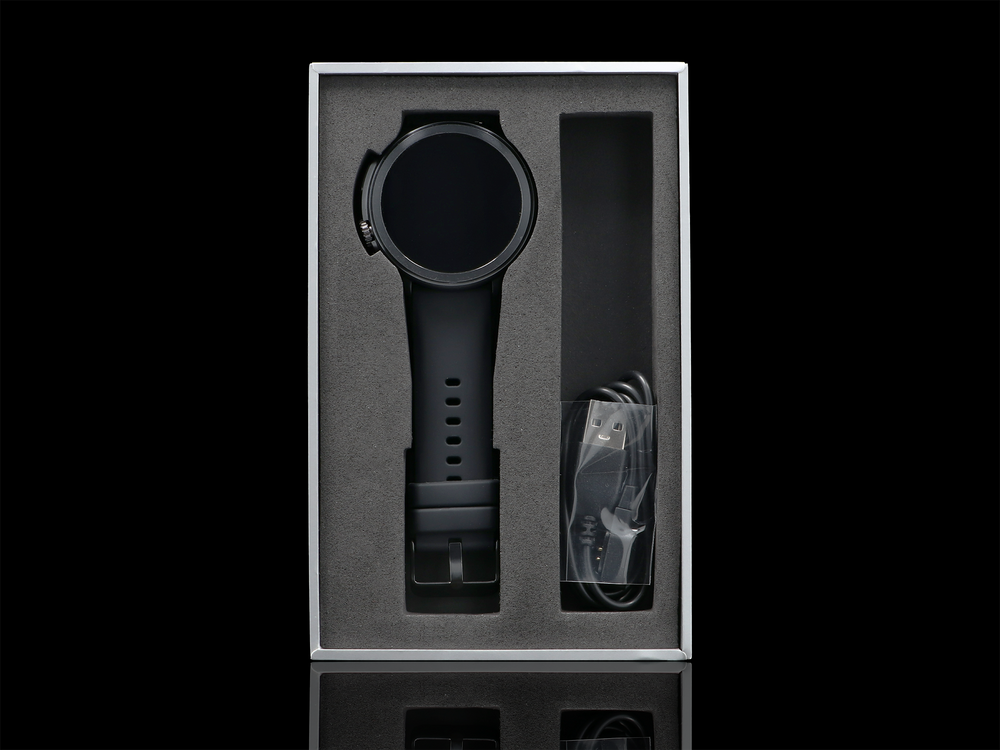 Czarny smartwatch z kablem ładującym w pudełku.