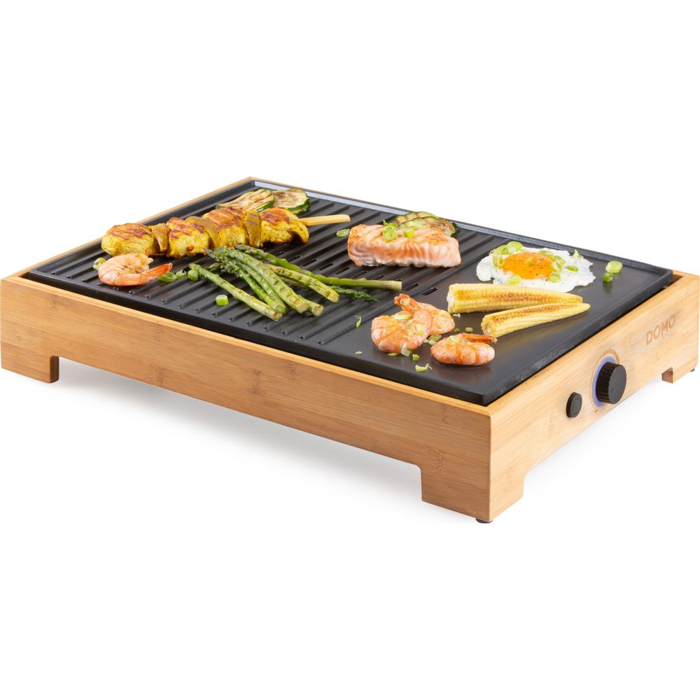Elektrischer Grill mit Bambusrahmen, belegt mit Garnelen, Spießen, Spargel, Lachs und Mais.