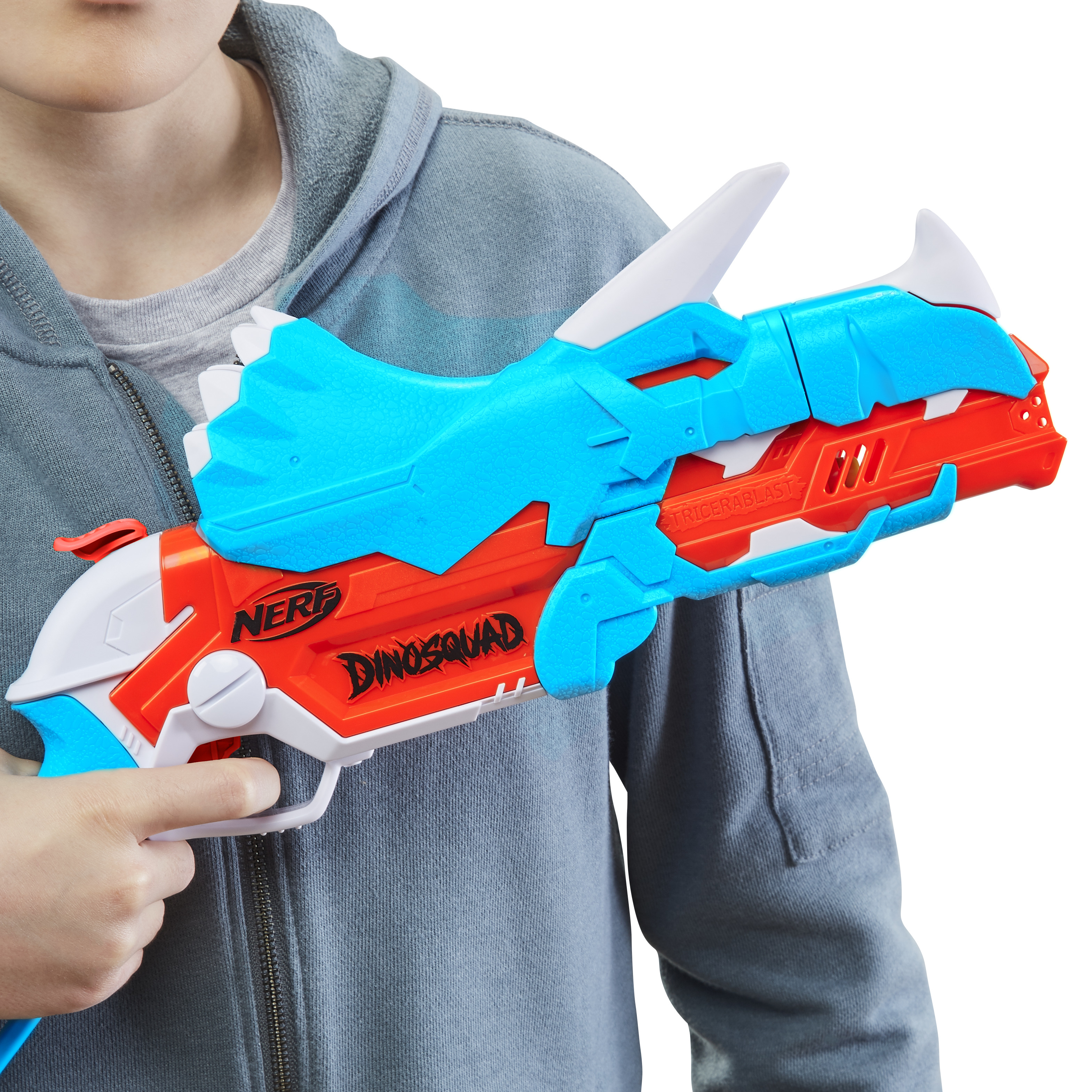Ein Kind hält eine orange-blaue Nerf DinoSquad-Spielzeugpistole mit Dinosaurier-Motiv.