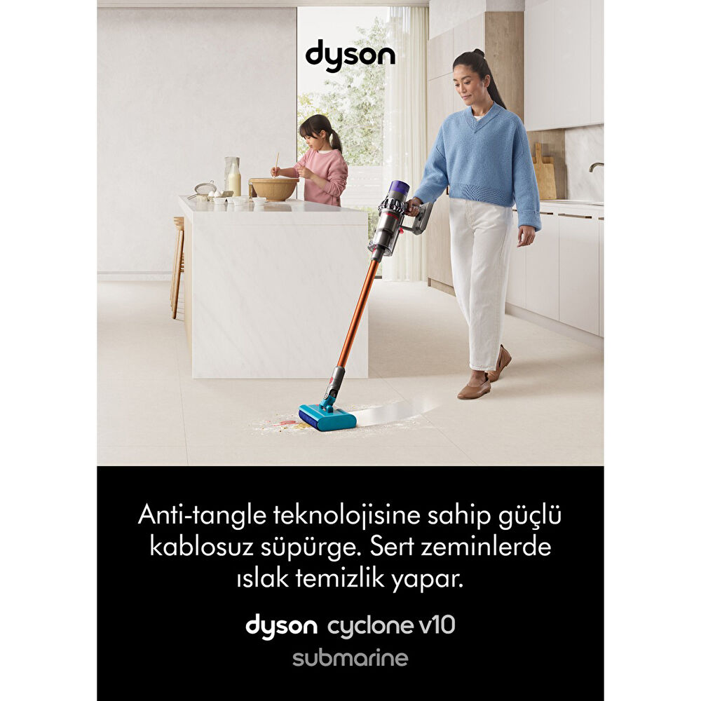 Mujer aspira con Dyson, niño ayuda en cocina. Limpieza de suelos.