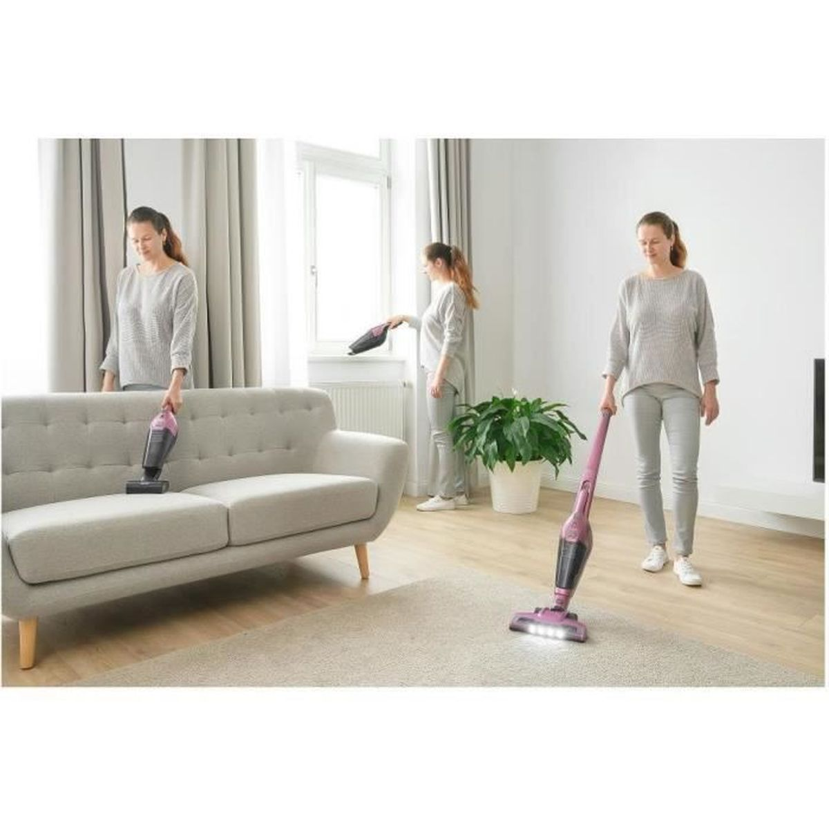 Una donna pulisce un divano e un tappeto con un aspirapolvere a mano rosa.