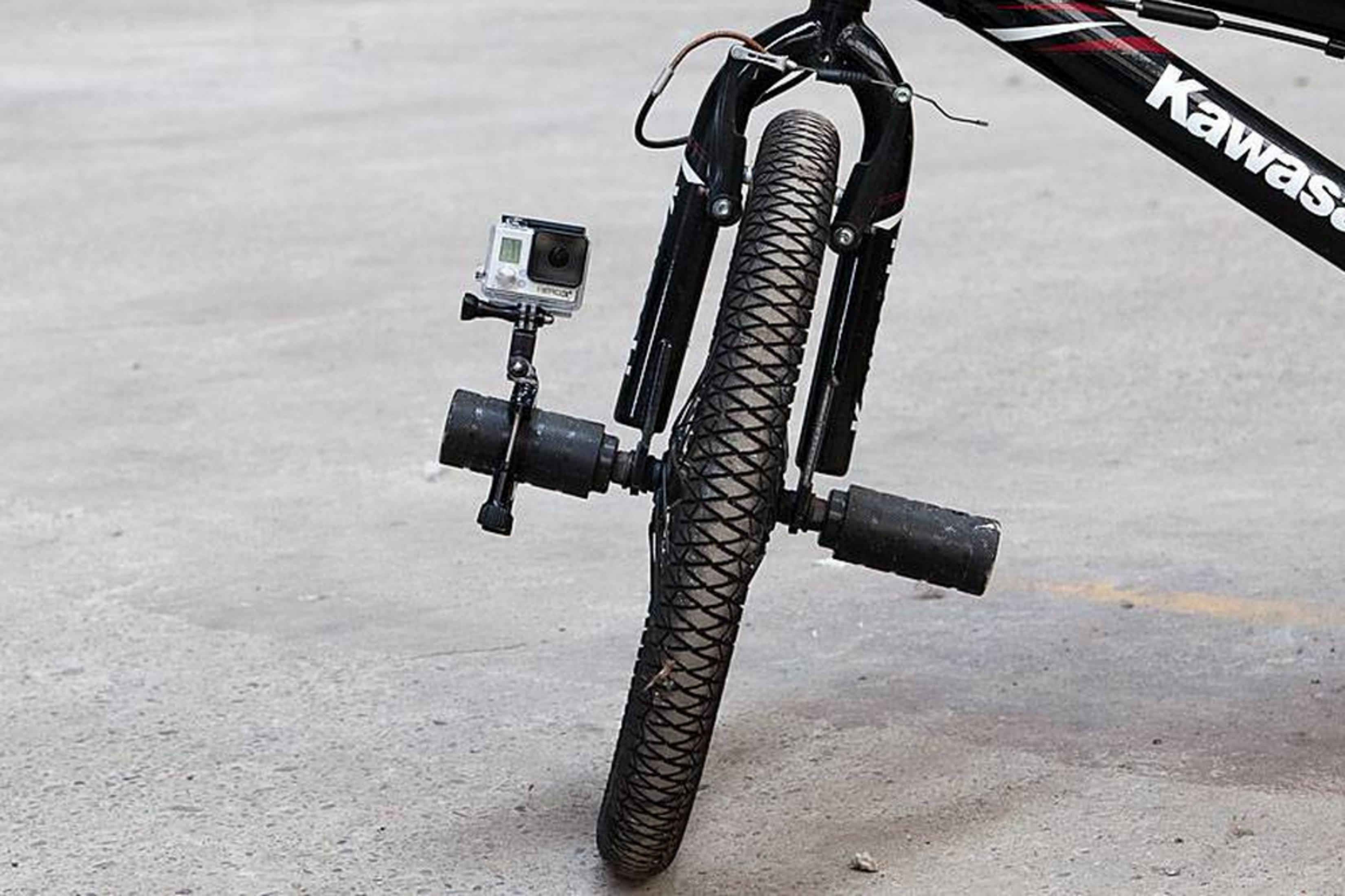 Ein Fahrrad mit einer GoPro-Kamera und zwei Stangen, die am Rad befestigt sind.