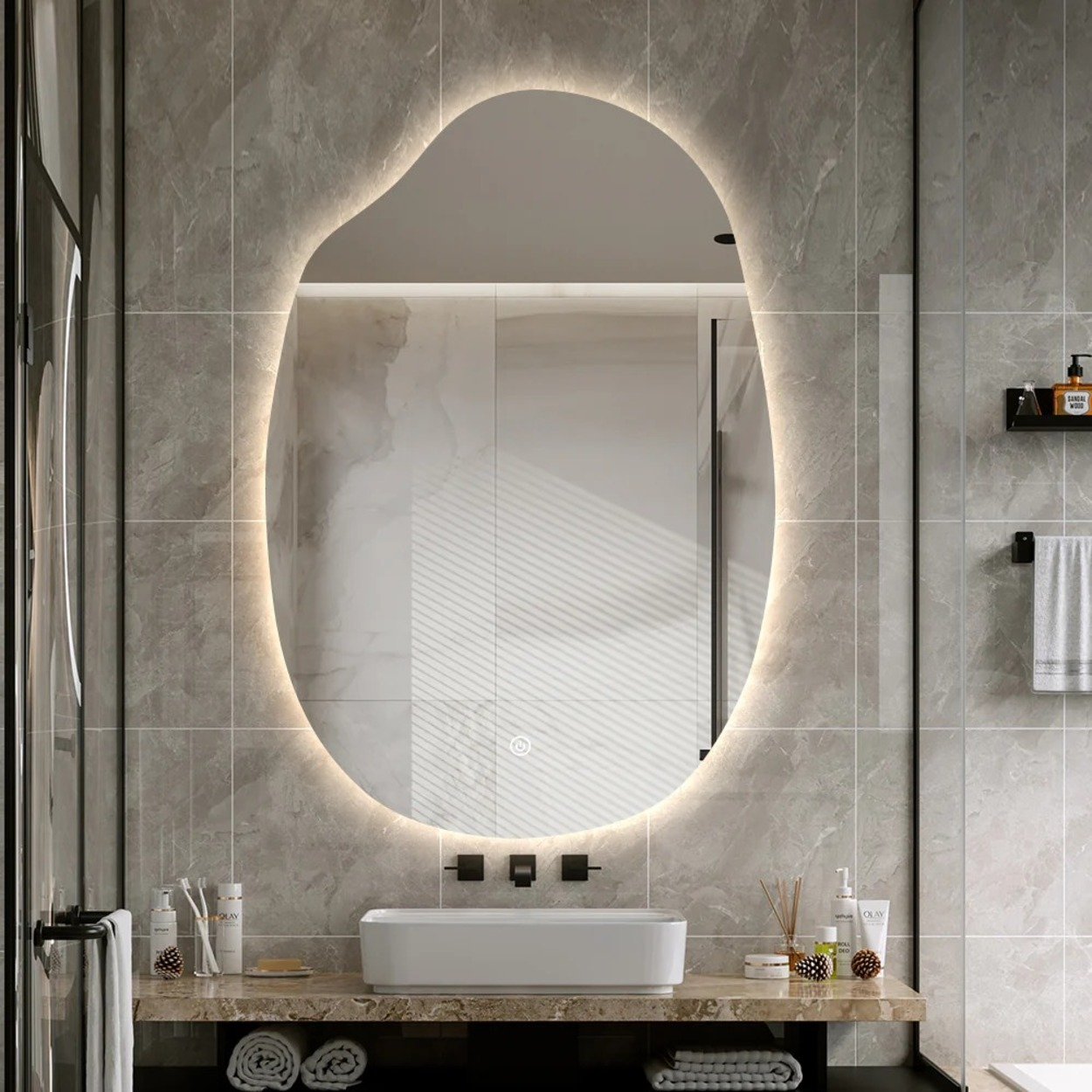 Een moderne badkamer met een grote, onregelmatig gevormde spiegel met zachte LED-verlichting.