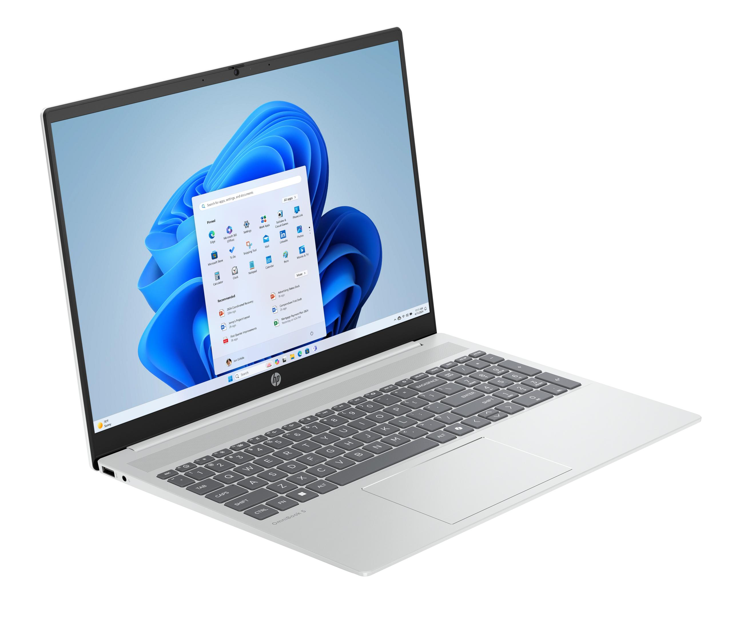 Ein silberner Laptop mit geöffnetem Windows 11 Startmenü und Tastatur.