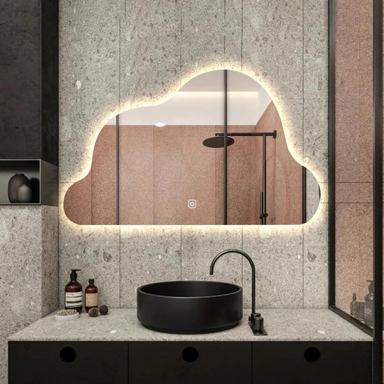Wolk-vormige spiegel met LED-verlichting boven een zwart wastafel en kraan.