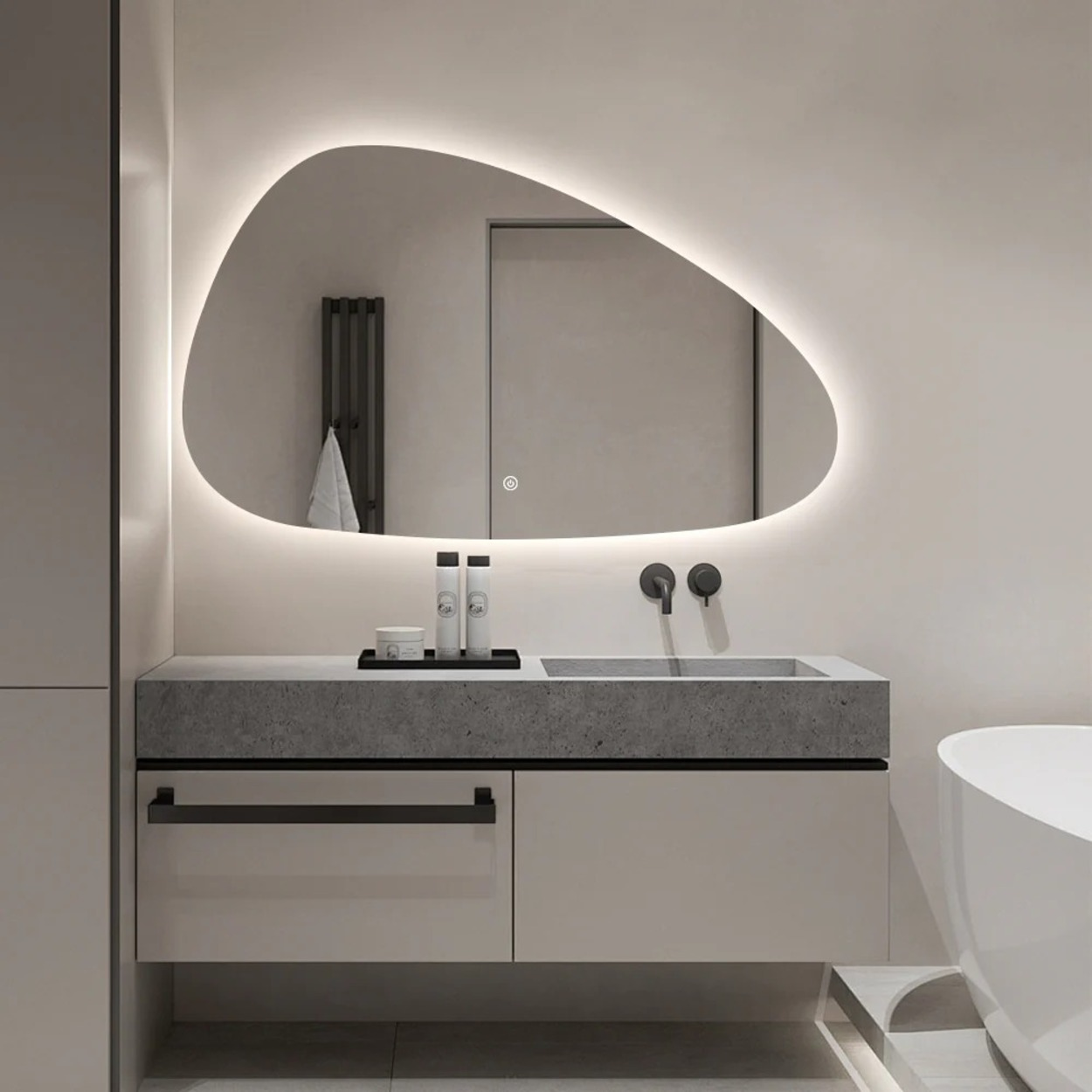 Moderne badkamer met verlichte spiegel, betonnen wastafel en vrijstaande badkuip.