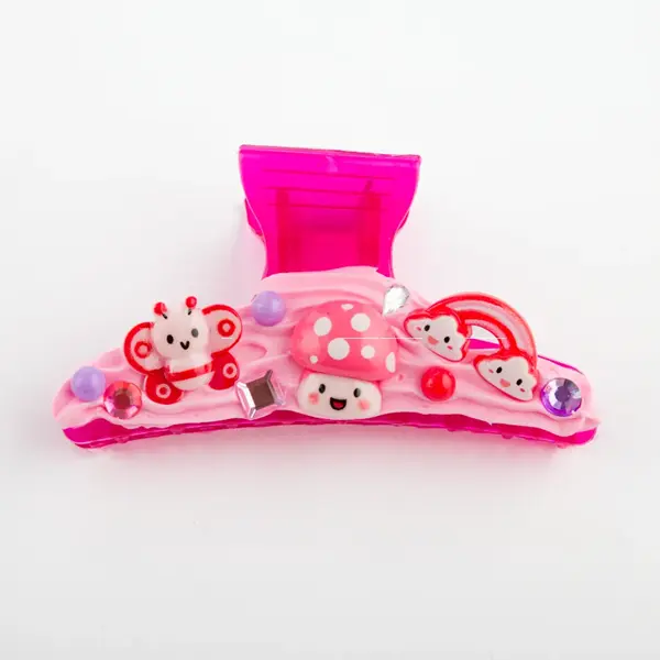 Un clip de garra para el cabello rosa con diseños de mariposa, hongo y arcoíris.