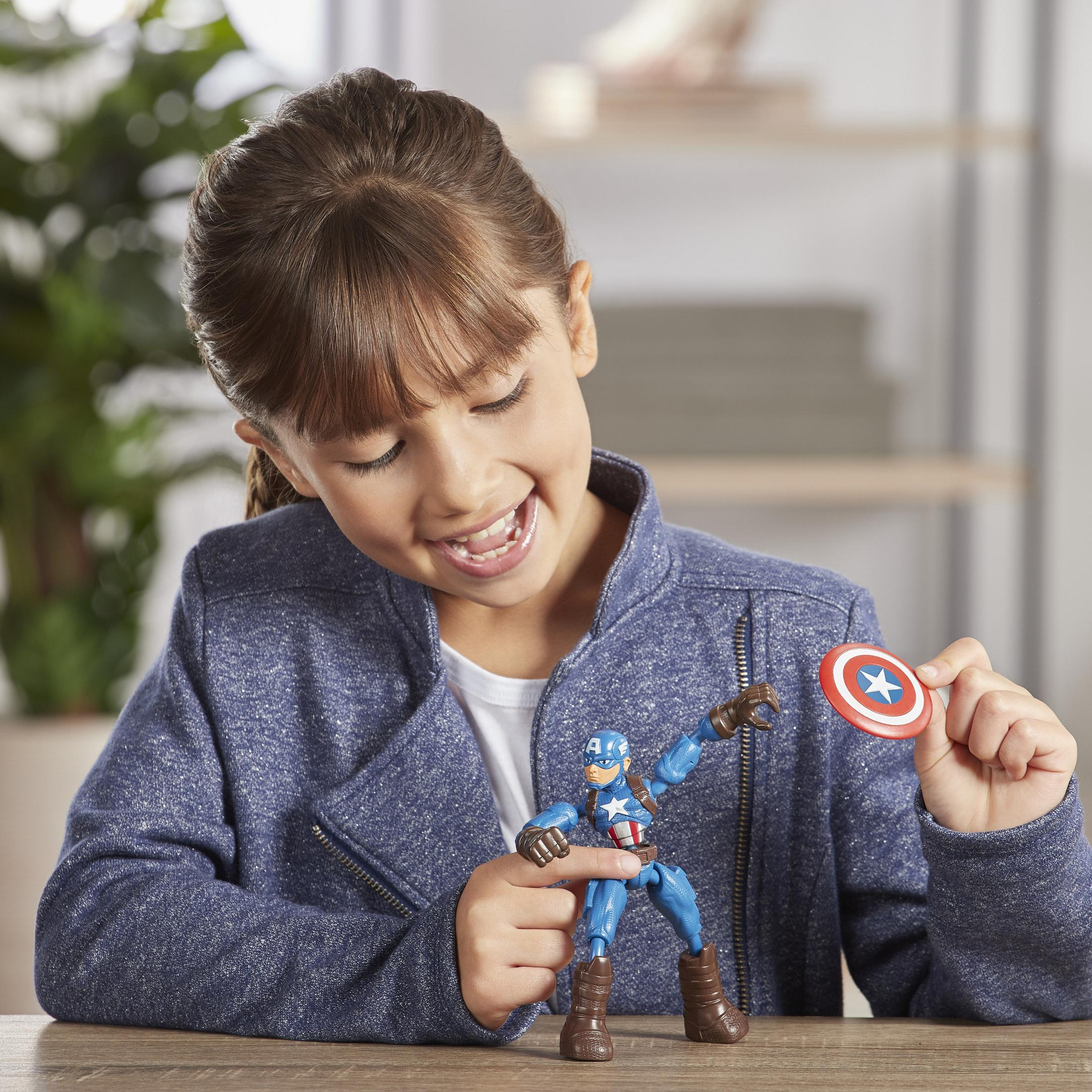 Una bambina gioca con una action figure e uno scudo di Capitan America in una stanza.