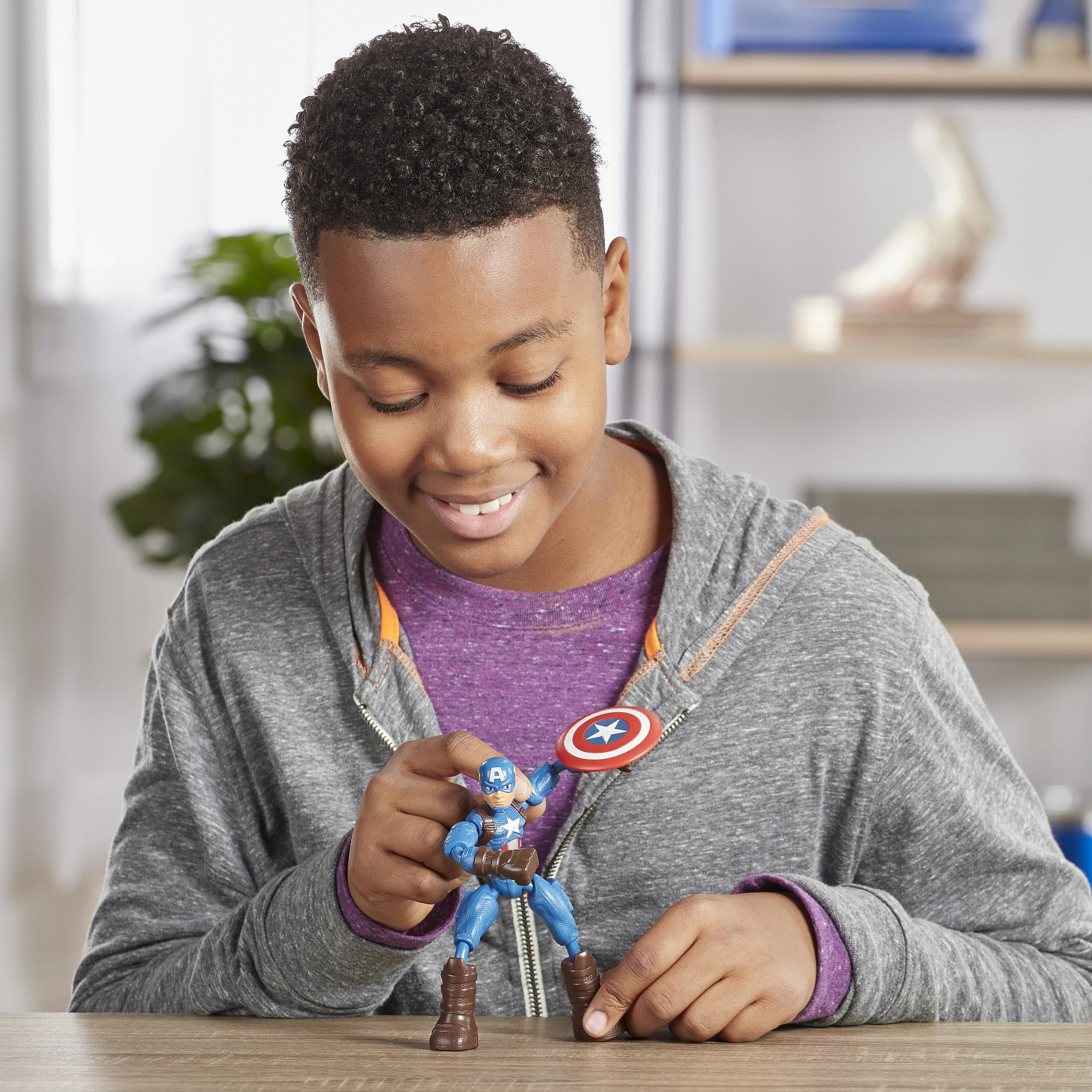 Un ragazzo tiene in mano un action figure di Capitan America con scudo.