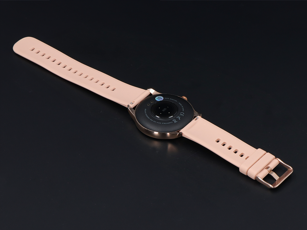 Różowy smartwatch z czarną tarczą i kopertą w kolorze różowego złota na ciemnym tle.