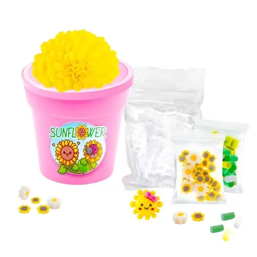 Maceta rosa con flor amarilla, bolsas de girasoles pequeños y piezas verdes/blancas.