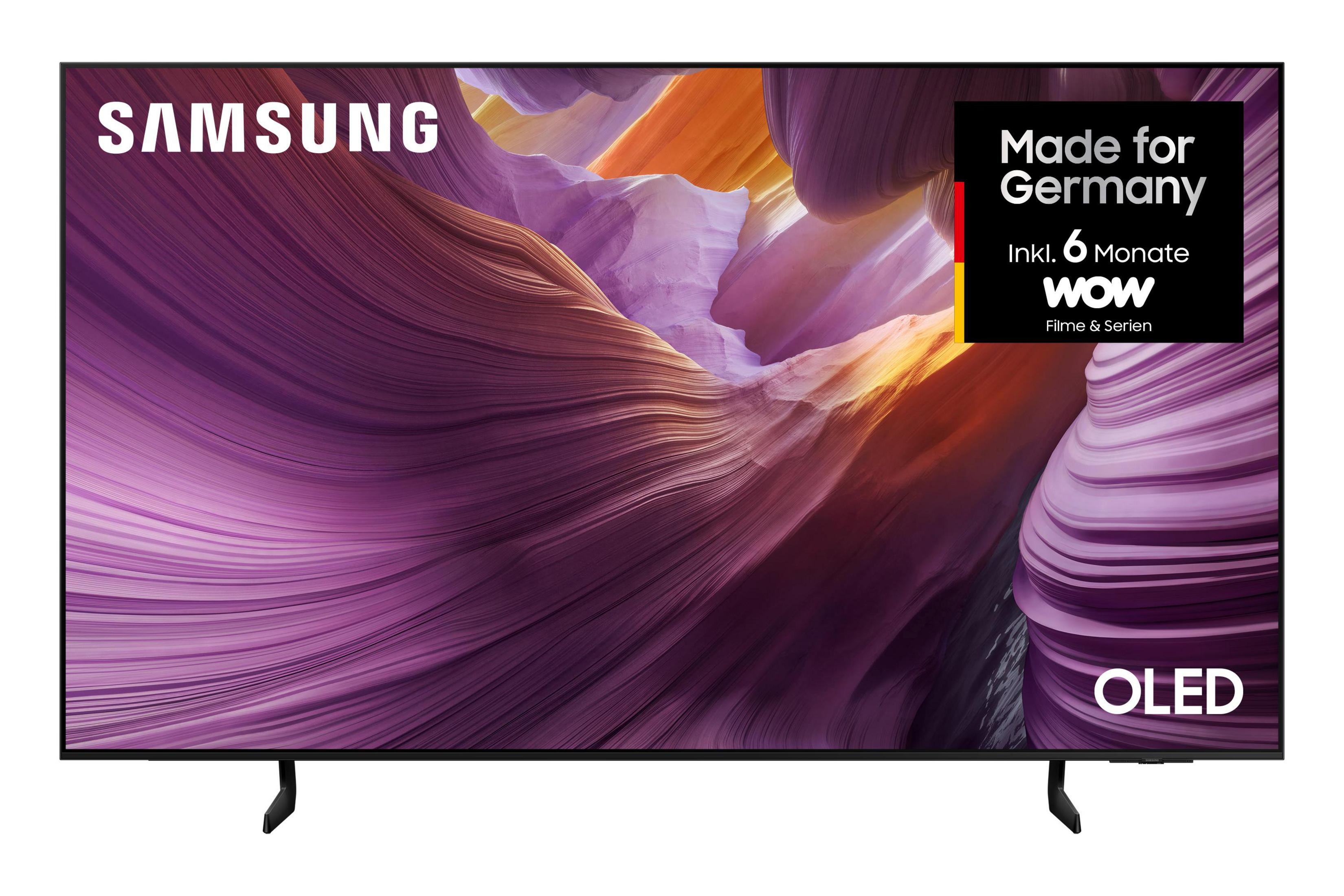 Telewizor Samsung OLED z abstrakcyjnym tłem fioletowo-pomarańczowym. Etykieta 'Made for Germany'.