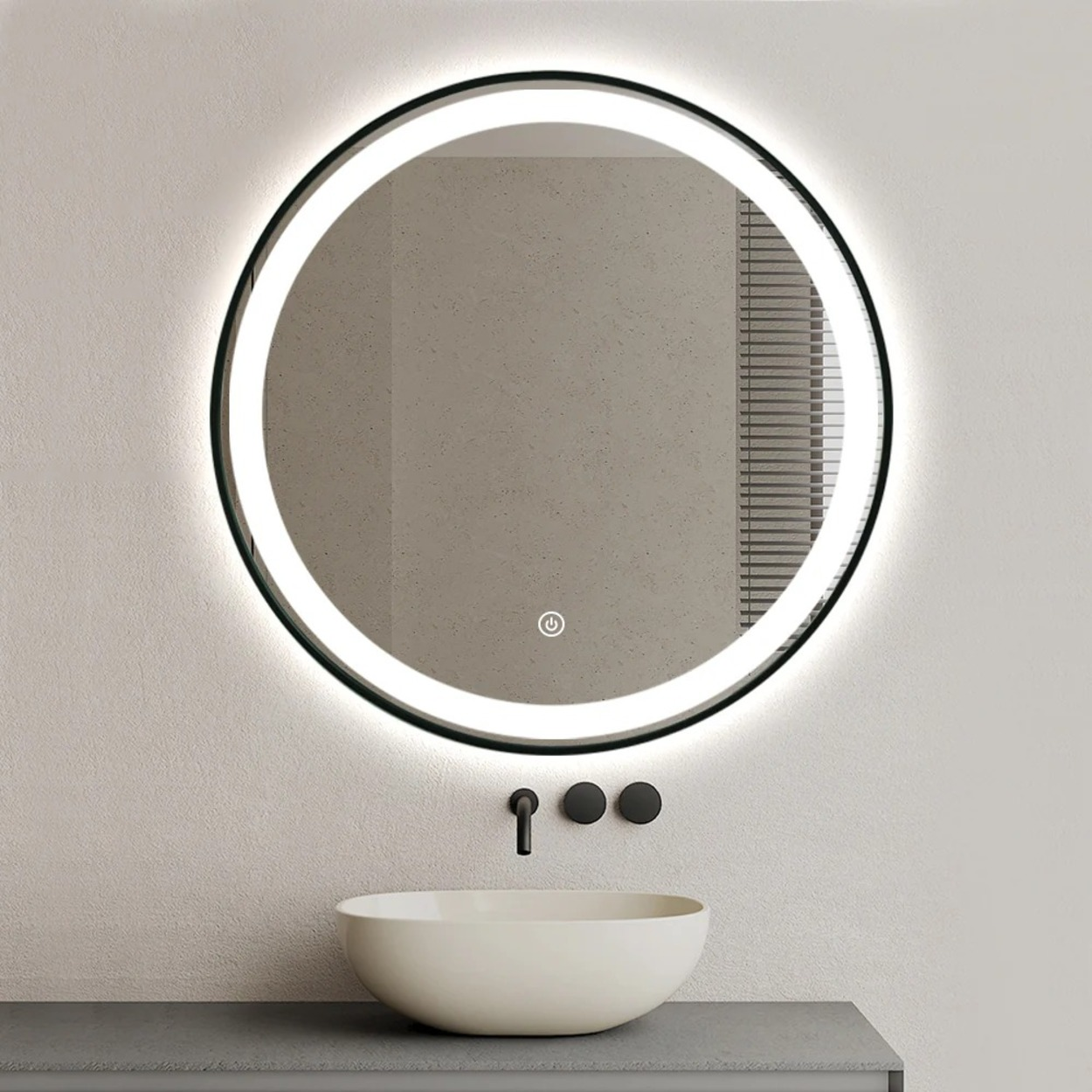 Een ronde spiegel met LED-verlichting boven een wastafel en kraan.