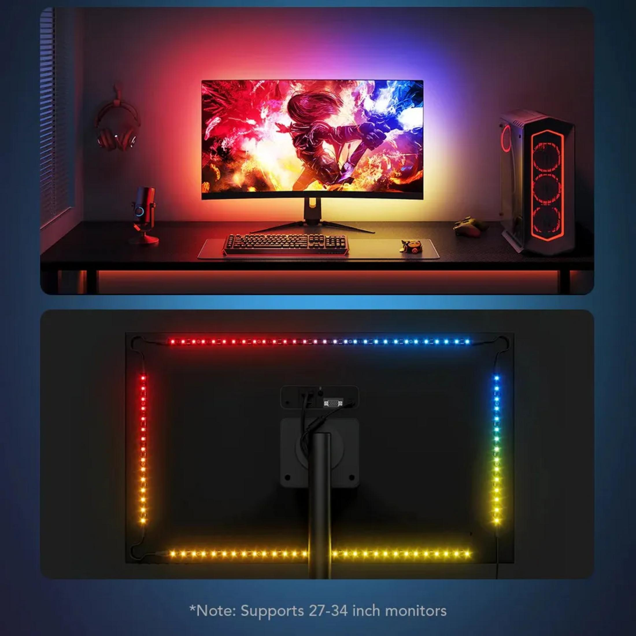 Configurazione da gioco con luci RGB su monitor, PC e scrivania. Il monitor mostra arte di gioco.