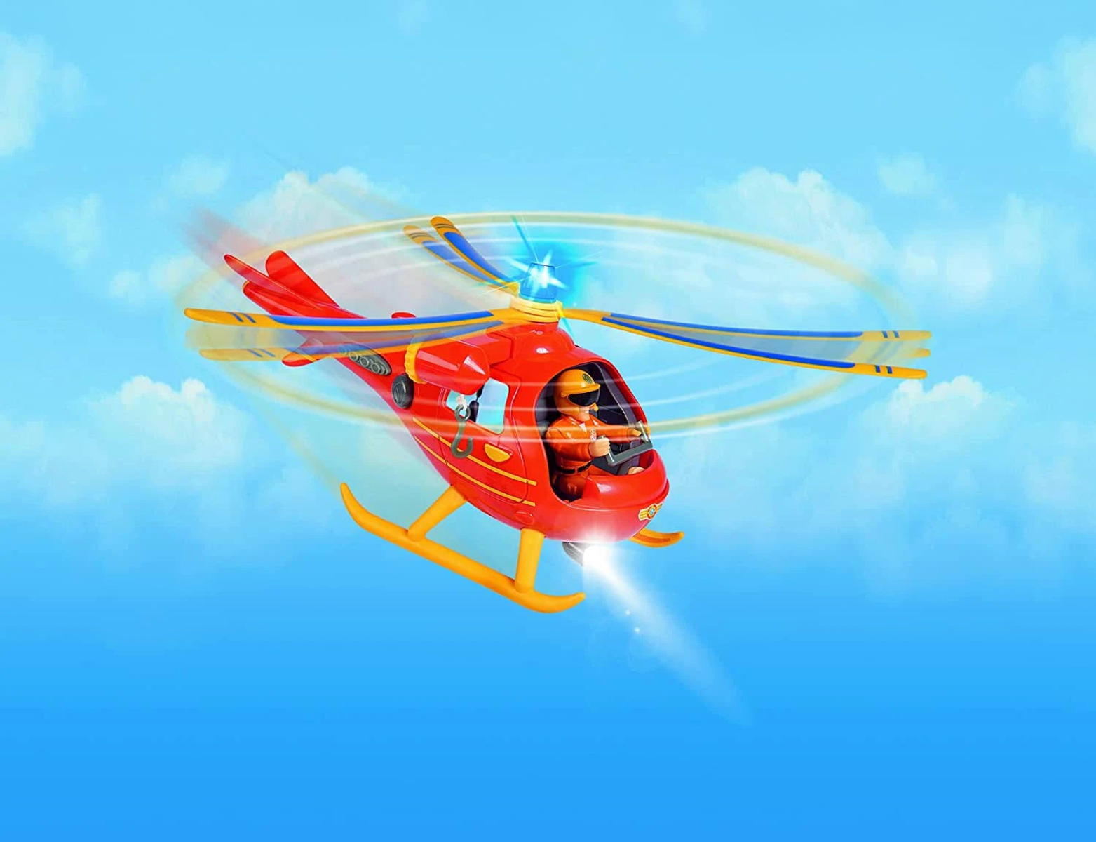 Czerwony helikopter z żółtymi płozami leci na błękitnym niebie.