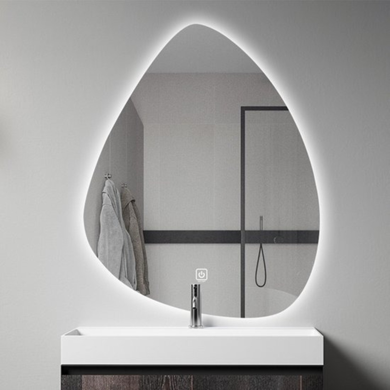 Een asymmetrische spiegel met LED-verlichting boven een wastafel met kraan.