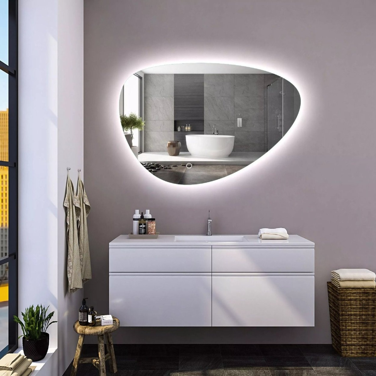 Moderne badkamer met verlichte spiegel, wit wastafelmeubel, badkuip en douche.