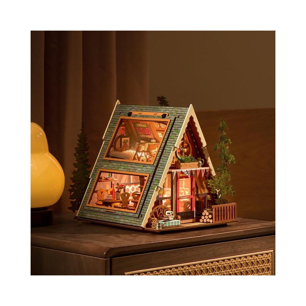 Una casa miniatura detallada con luces, muebles y árboles sobre una mesa.