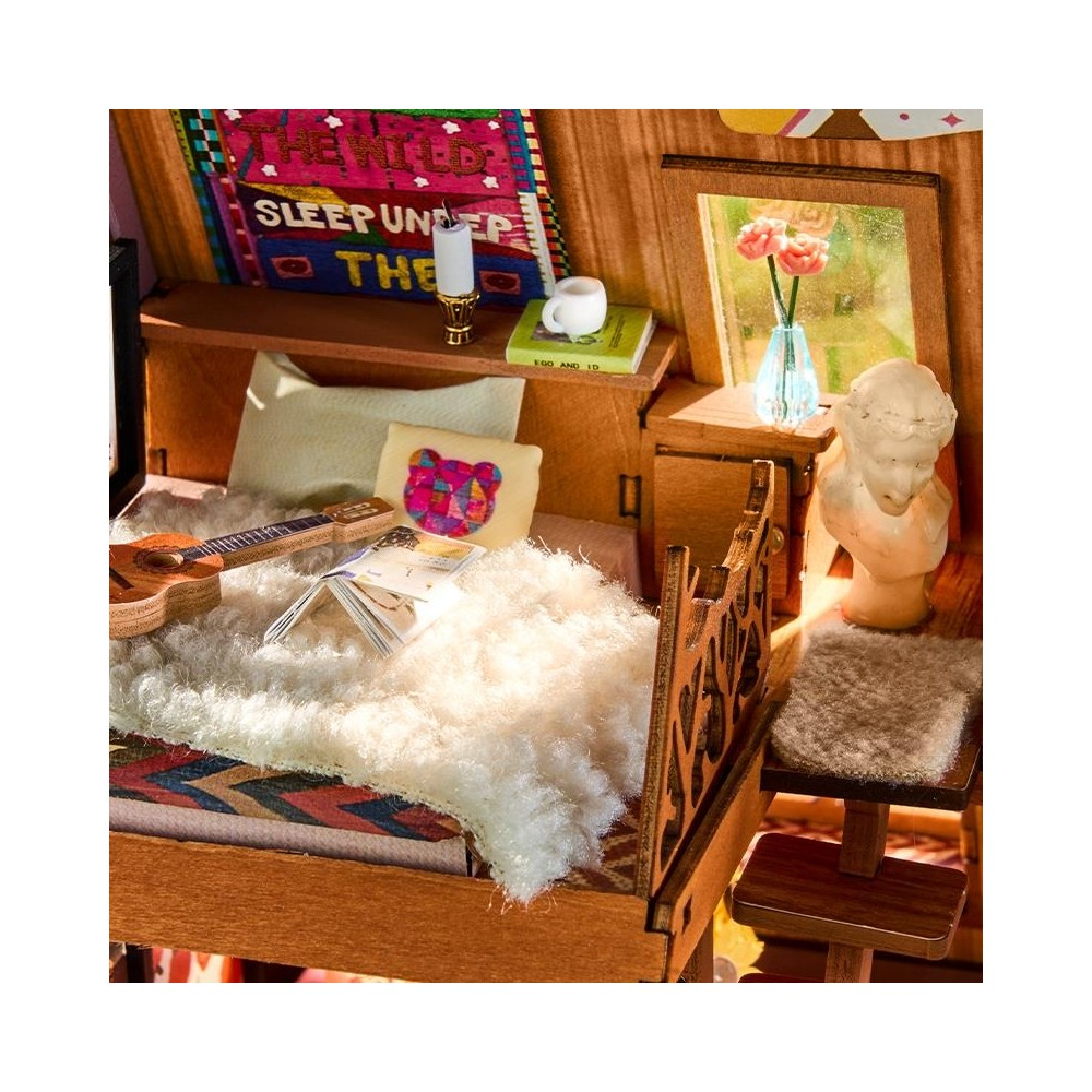 Un dormitorio bohemio en miniatura con cama, guitarra, libros y un busto.