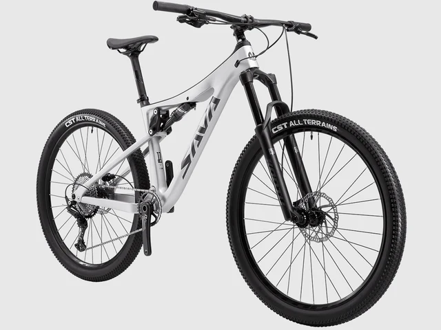 Ein silbernes Mountainbike mit Vollfederung und schwarzen Reifen steht vor grauem Hintergrund.